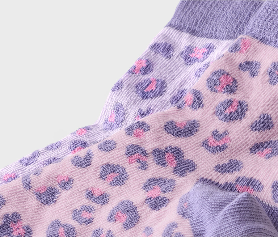 Gros plan de chaussettes avec des bords-côtes violets et un motif léopard rose.