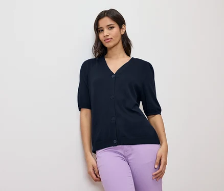 Femme portant un cardigan bleu marine à manches courtes et un pantalon violet.