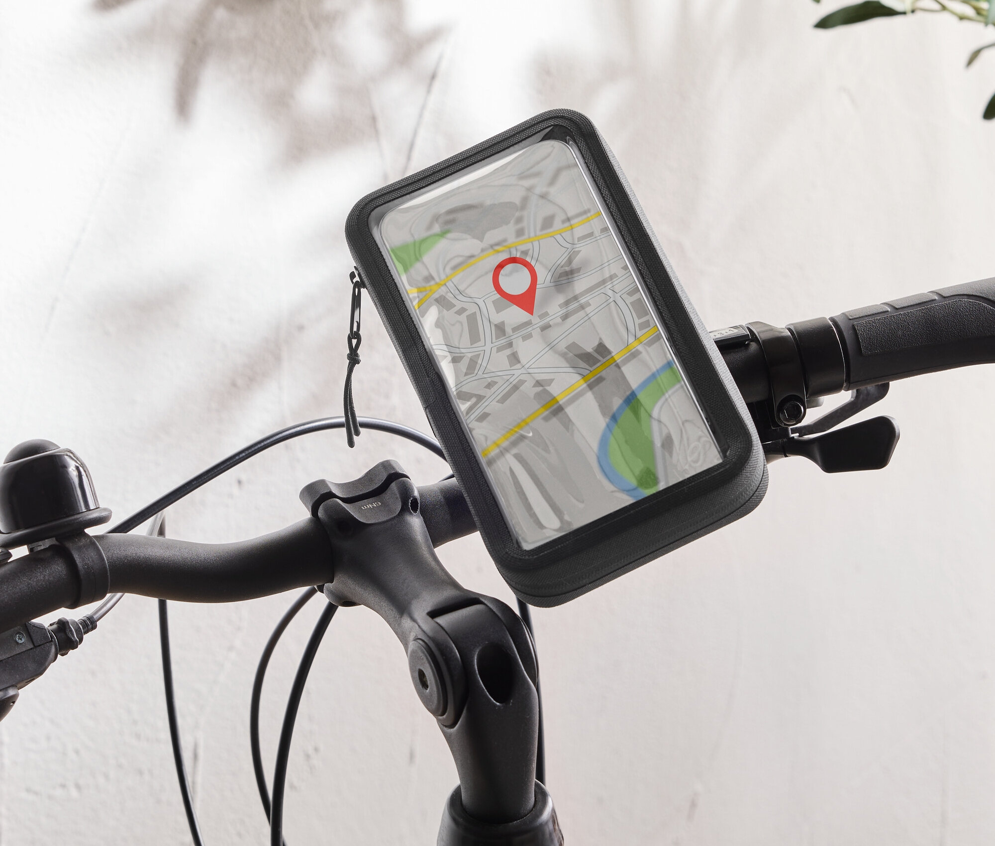 Un vélo noir avec un support de téléphone portable sur le guidon affichant une application de carte avec une punaise rouge.