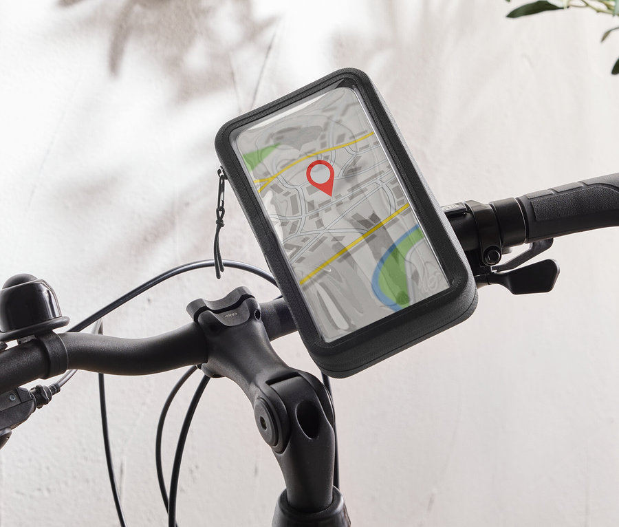 Un vélo noir avec un support de téléphone portable sur le guidon affichant une application de carte avec une punaise rouge.