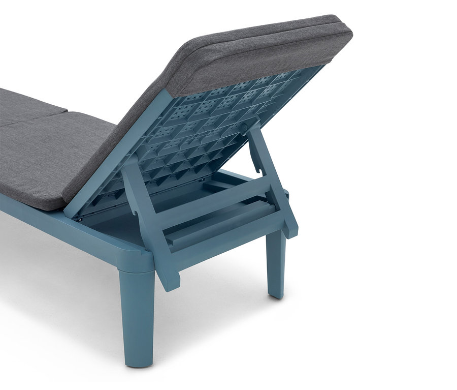 Gros plan sur une chaise longue bleue avec des coussins gris, dossier relevé.
