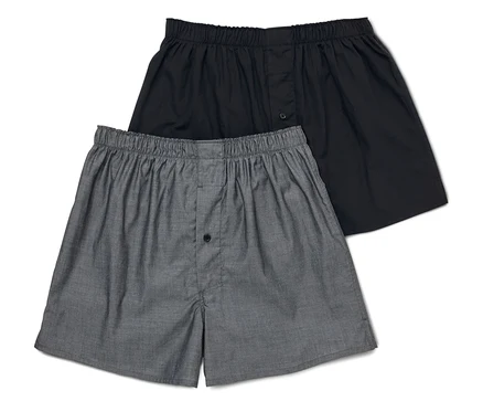 Deux boxers pour hommes, un gris et un noir, sont posés l'un sur l'autre.