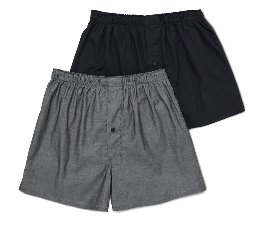 Deux boxers pour hommes, un gris et un noir, sont posés l'un sur l'autre.
