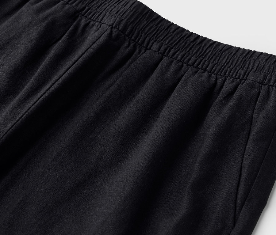 Gros plan de la taille d'un pantalon noir avec une ceinture élastique.