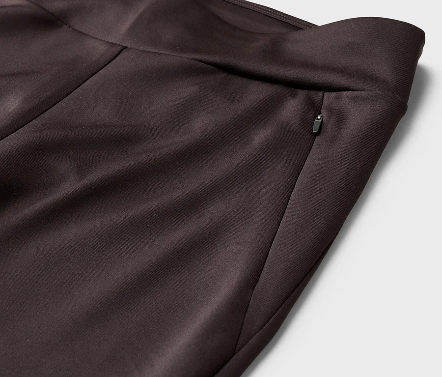 Gros plan d'un pantalon marron avec une poche zippée à la taille.