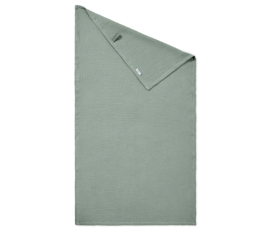 Un tissu en mousseline vert clair est plié sur un fond blanc.