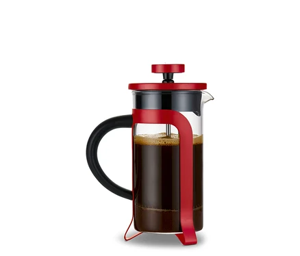 Une cafetière à piston rouge de 300 ml avec 2 tasses remplie de café. Un set cadeau « Amour-To-Go » est visible en arrière-plan.
