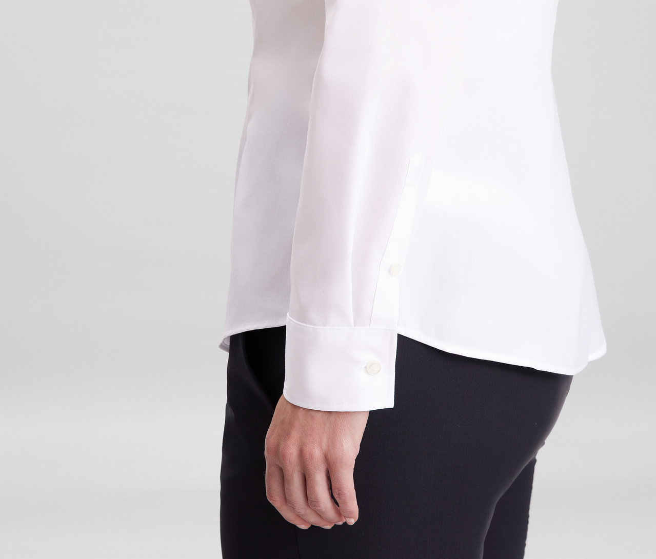 Personne portant un chemisier Seidensticker Slim Fit non iron blanc et un pantalon noir, la manche avec manchette est visible.