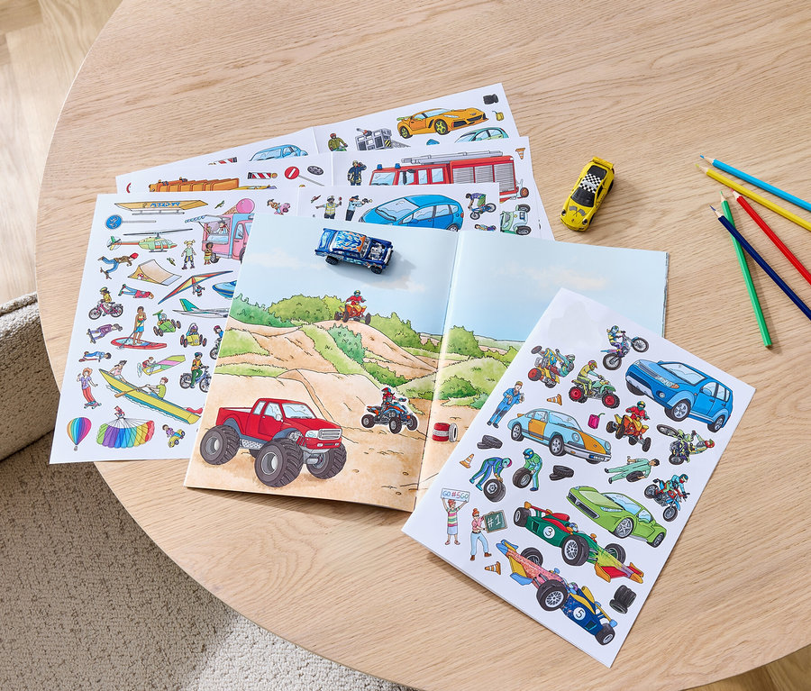Sur une table, un livre d'autocollants «
Voitures
» ouvert et des crayons de couleur.