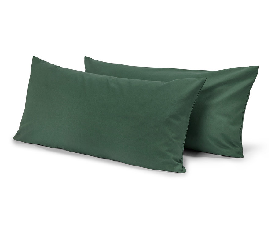 Deux oreillers rectangulaires verts, l'un légèrement derrière l'autre, sur un fond blanc.