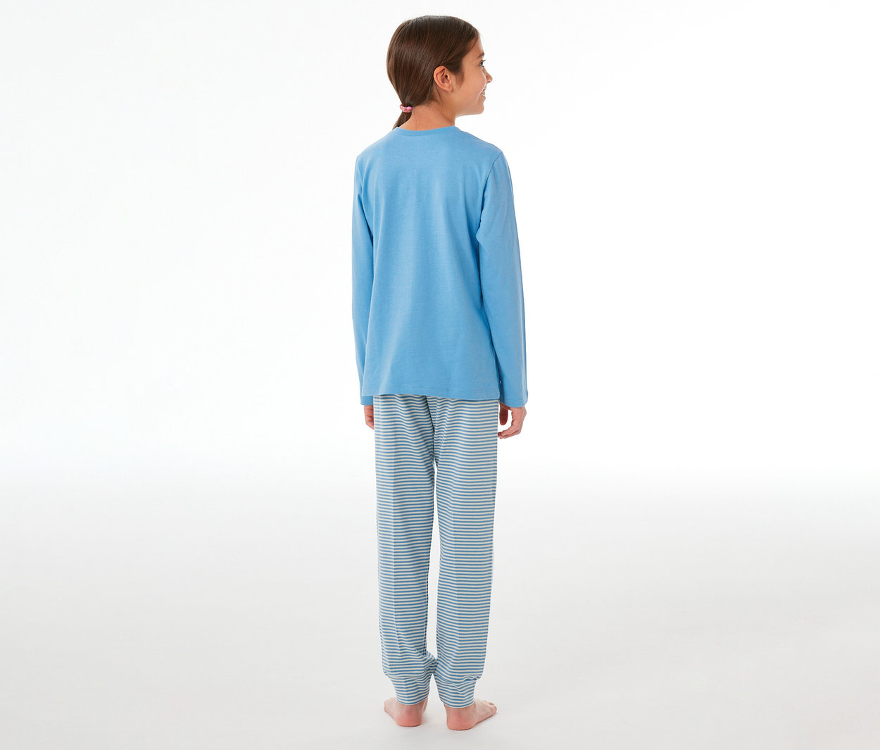 Fille de dos, légèrement tournée vers la droite, portant un pyjama enfant SCHIESSER composé d'un t-shirt bleu à manches longues et d'un pantalon rayé.