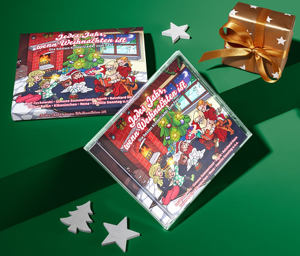 Sur un fond vert se trouvent le CD « Jedes Jahr, wenn Weihnachten ist », un cadeau et des décorations.
