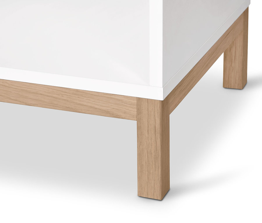 Détail d'une commode blanche »Eklund« avec penderie et pieds en bois clair.