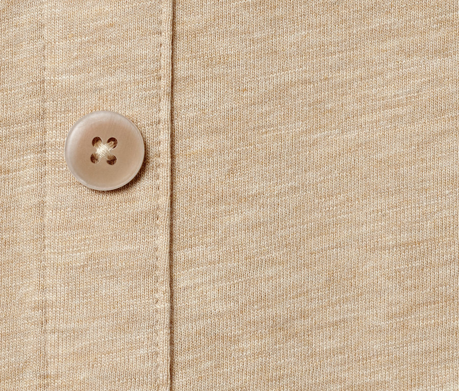 Gros plan sur un haut beige avec patte de boutonnage.