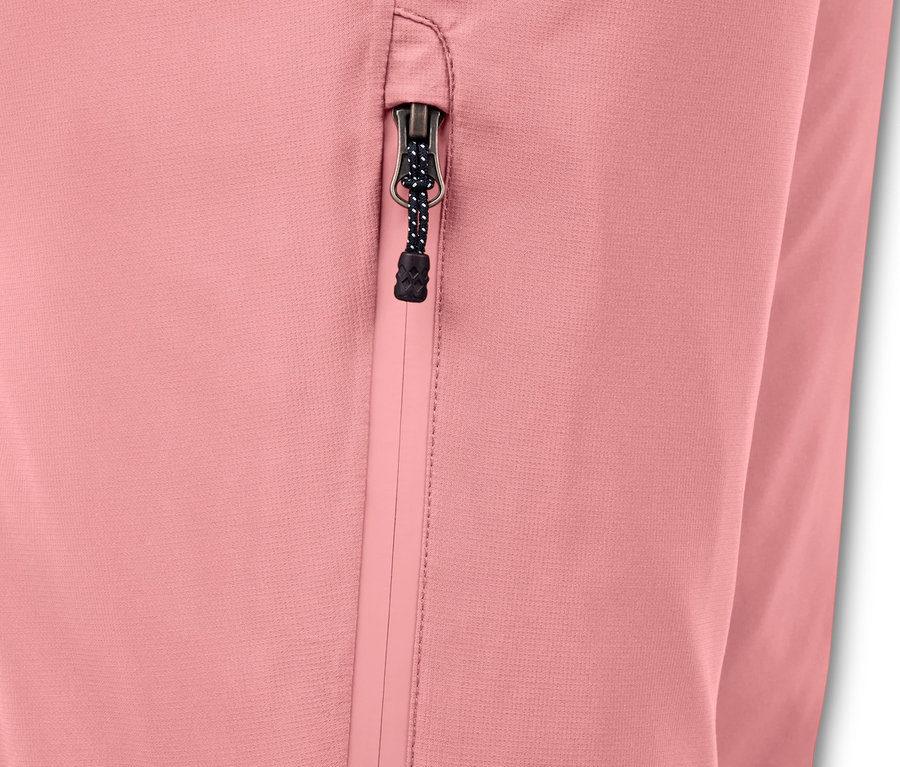 Détail d'un pantalon de ski et de snowboard rose avec une poche zippée.