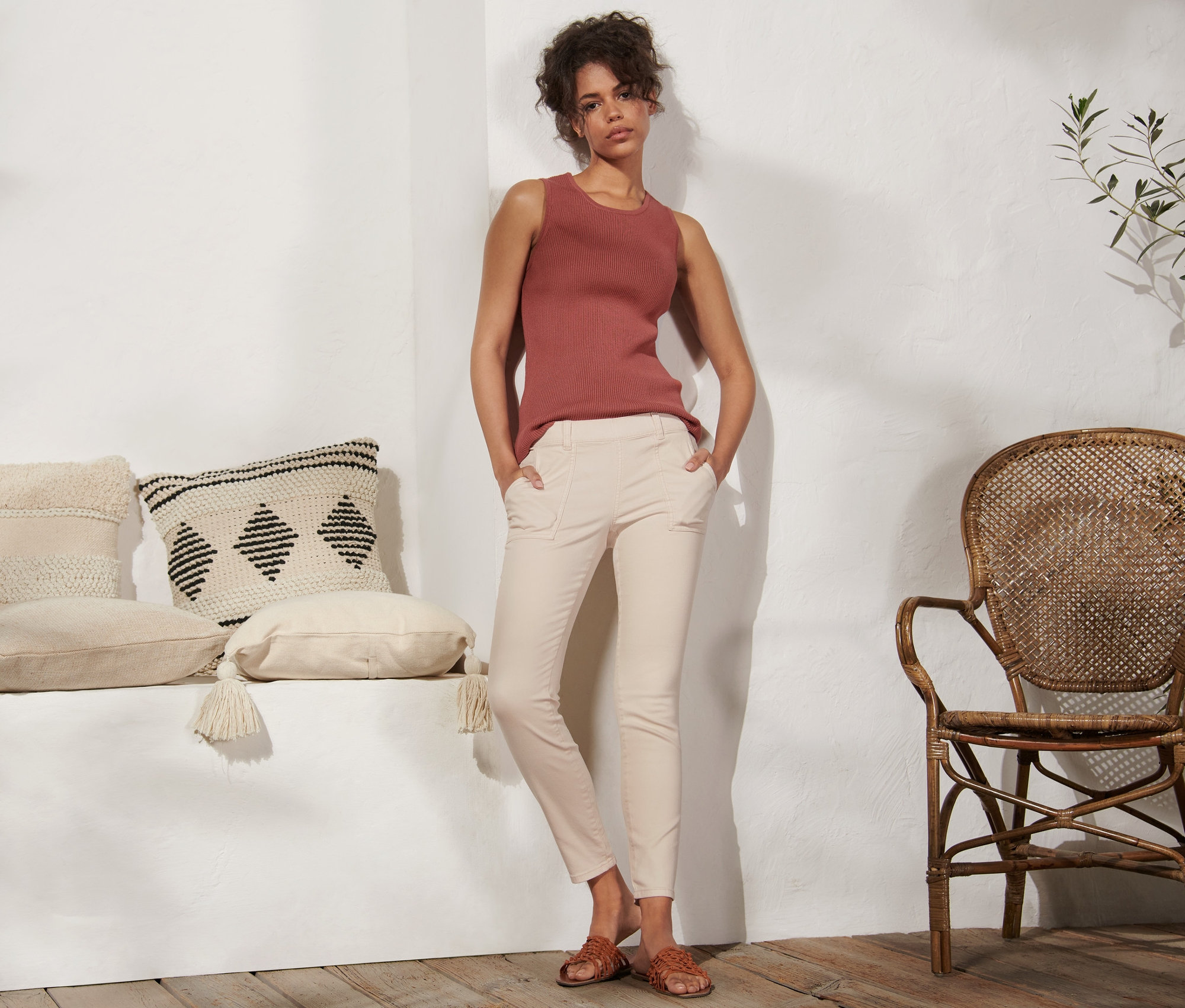 Une femme se tient debout, les mains dans les poches de son tregging.