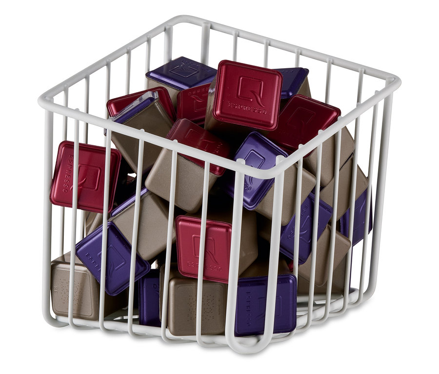 Un panier à capsules blanc rempli de capsules rouges, violettes et marron.