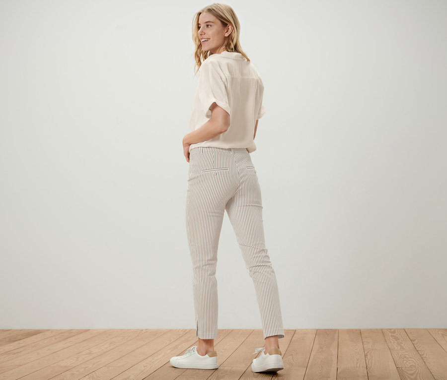 Blonde regardant par-dessus son épaule portant un pantalon rayé en twill stretch.