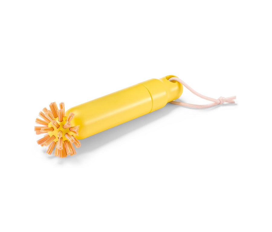 Brosse de vidange 2 en 1 jaune avec des poils orange et une cordelette de suspension rose.