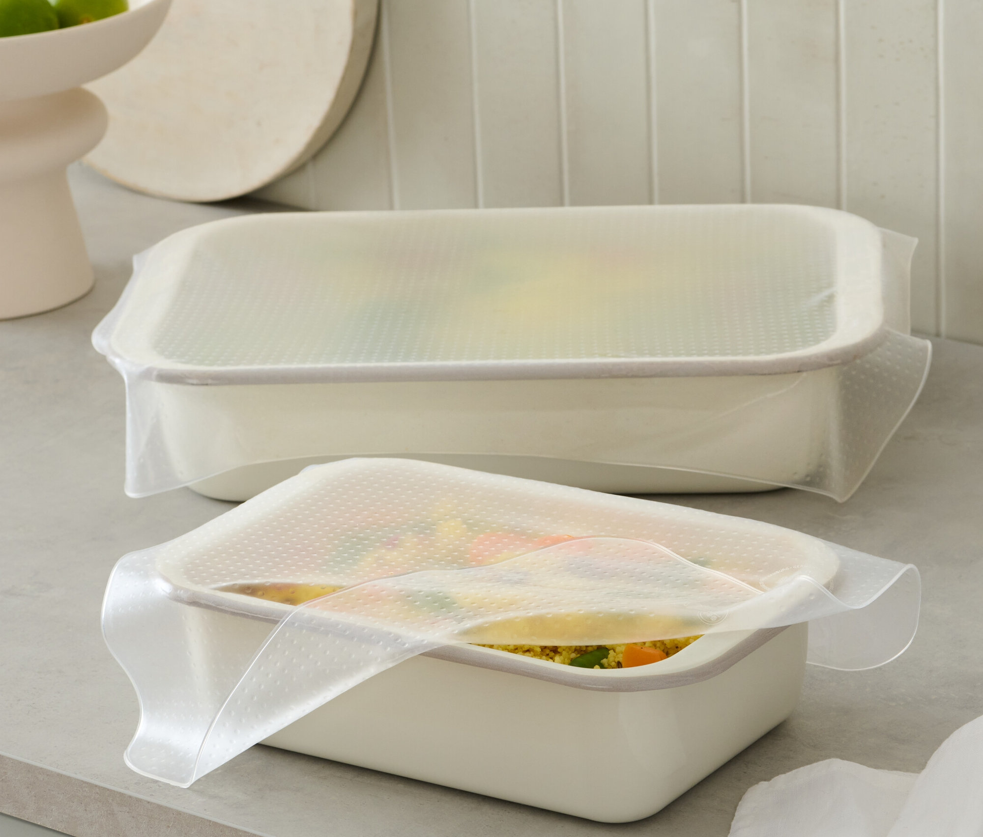Deux récipients blancs sont recouverts de 2 films alimentaires en silicone.