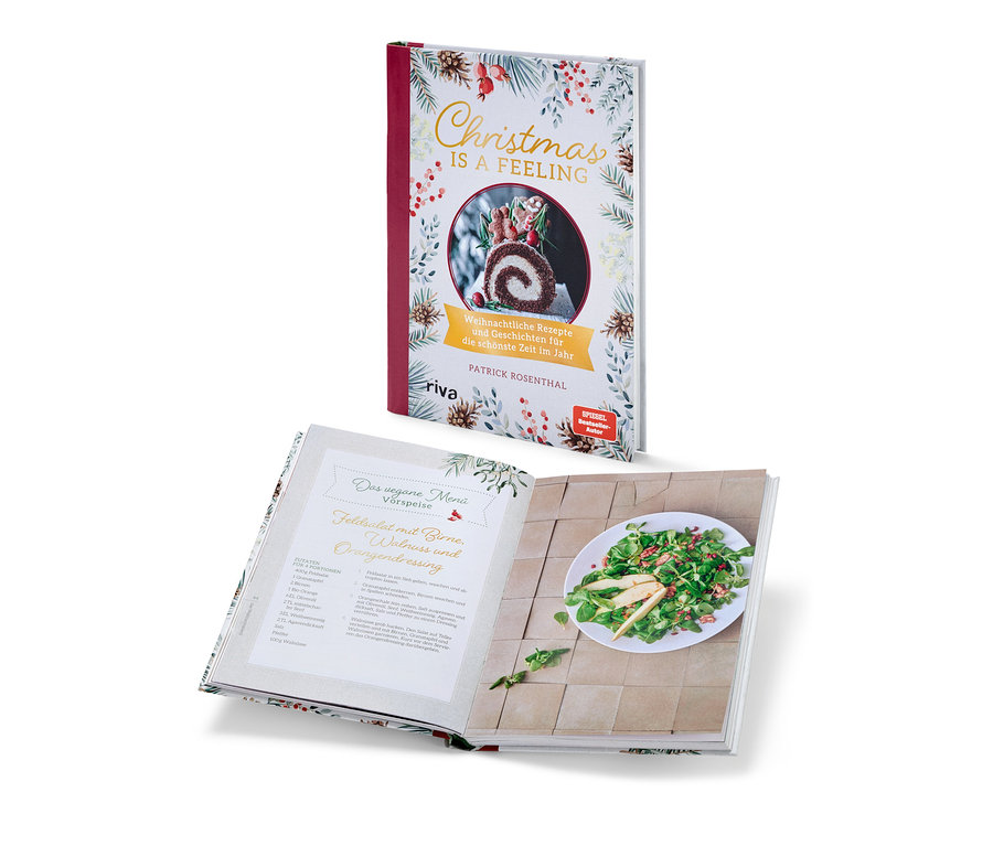 Deux livres de cuisine sur le thème de Noël. Un livre est fermé et se tient verticalement, l'autre est ouvert et repose horizontalement. On peut voir le livre « Christmas is a feeling » (en allemand).