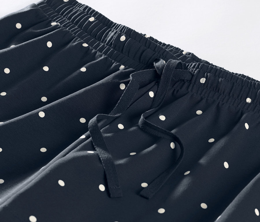 Gros plan sur un short de pyjama bleu marine à pois blancs avec cordon de serrage.
