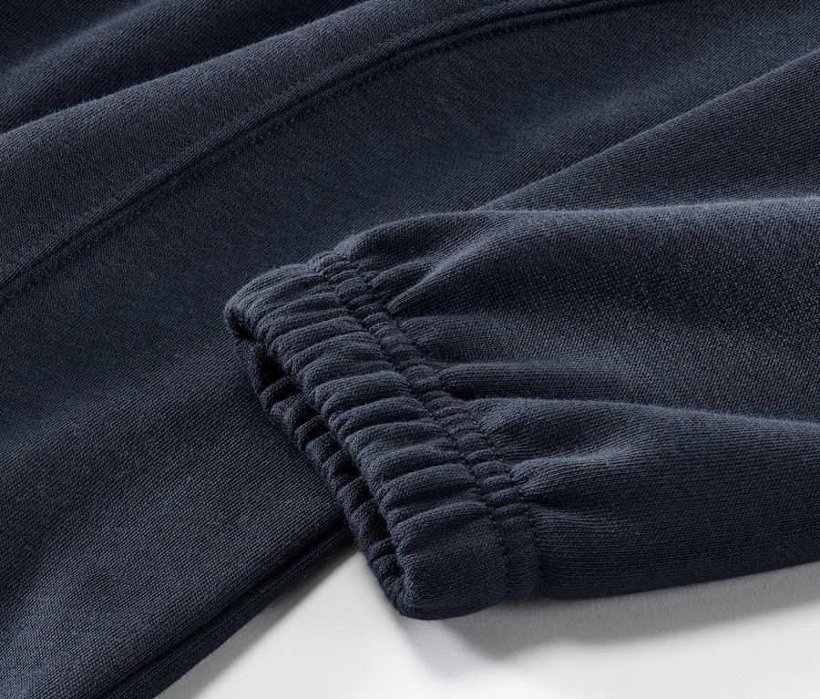 Détail d'un survêtement d’intérieur bleu foncé.