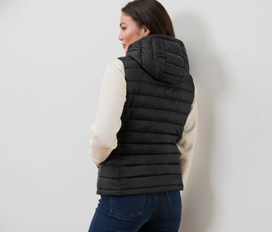 Femme portant un gilet sans manches matelassé à capuche.