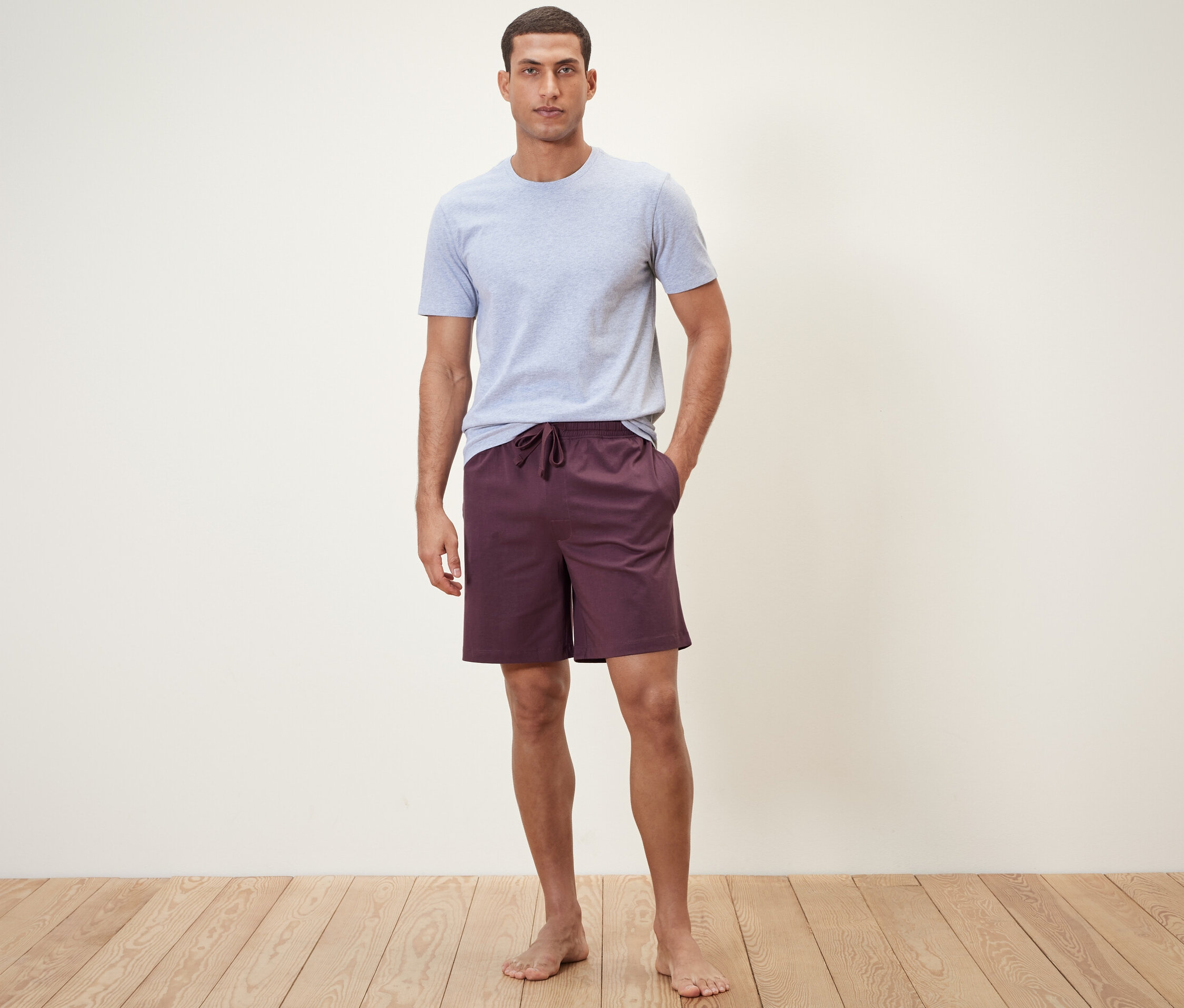Un homme debout portant un short relax et un t-shirt.