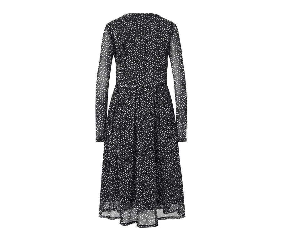 Une robe en mesh à pois noire à manches longues avec un motif à pois blancs.