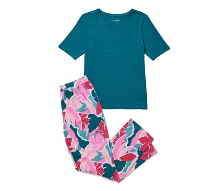 L'image montre un ensemble pyjama composé d'un t-shirt turquoise et d'un pantalon à motif floral rose, blanc et turquoise.