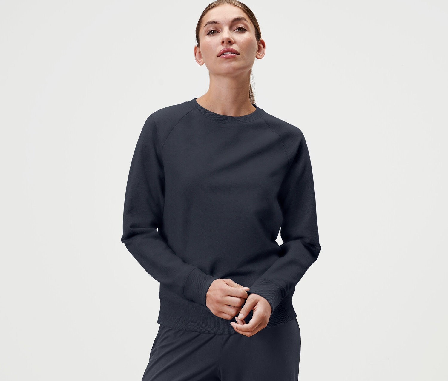 Femme portant un sweatshirt de yoga bleu marine.