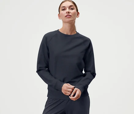 Femme portant un sweatshirt de yoga bleu marine.