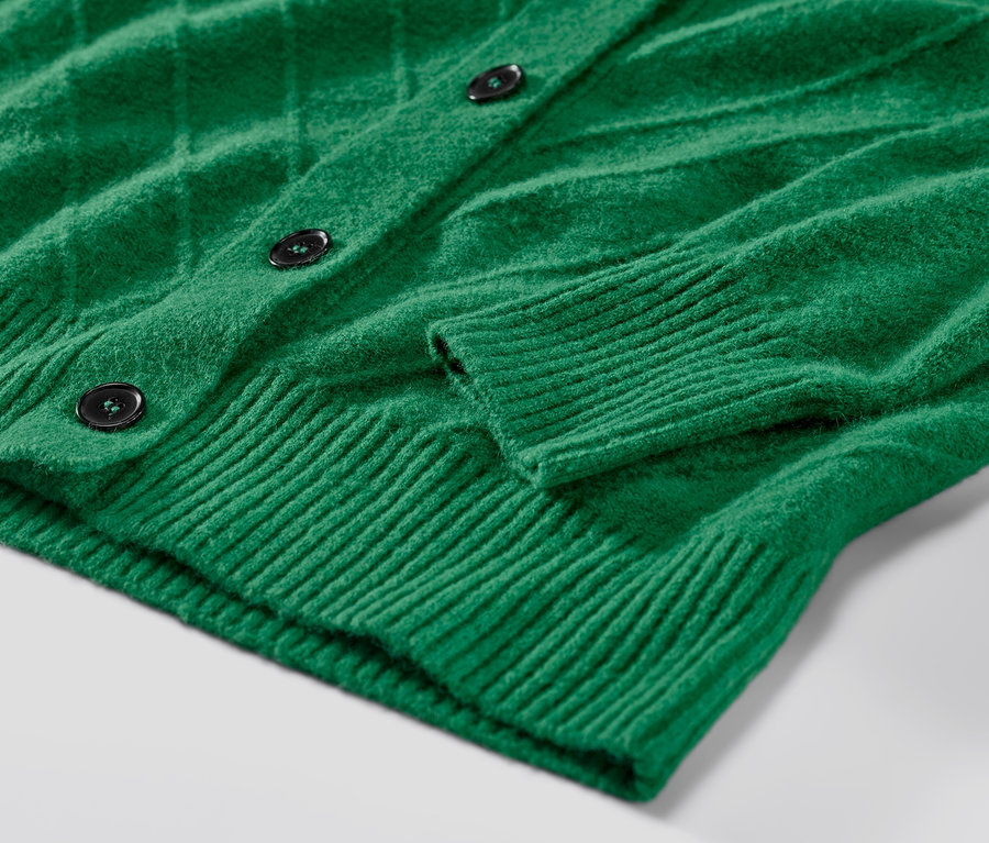 Vue détaillée d'un cardigan vert avec structure tricotée.