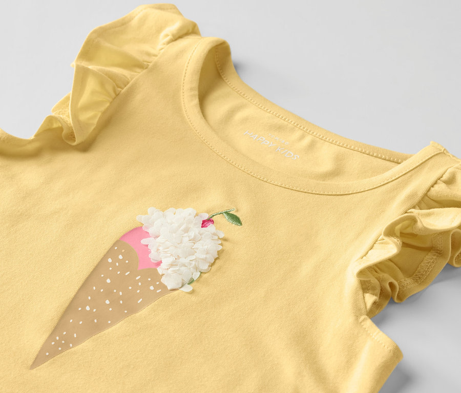 Chemise jaune pour enfant avec manches à volants et motif de crème glacée.