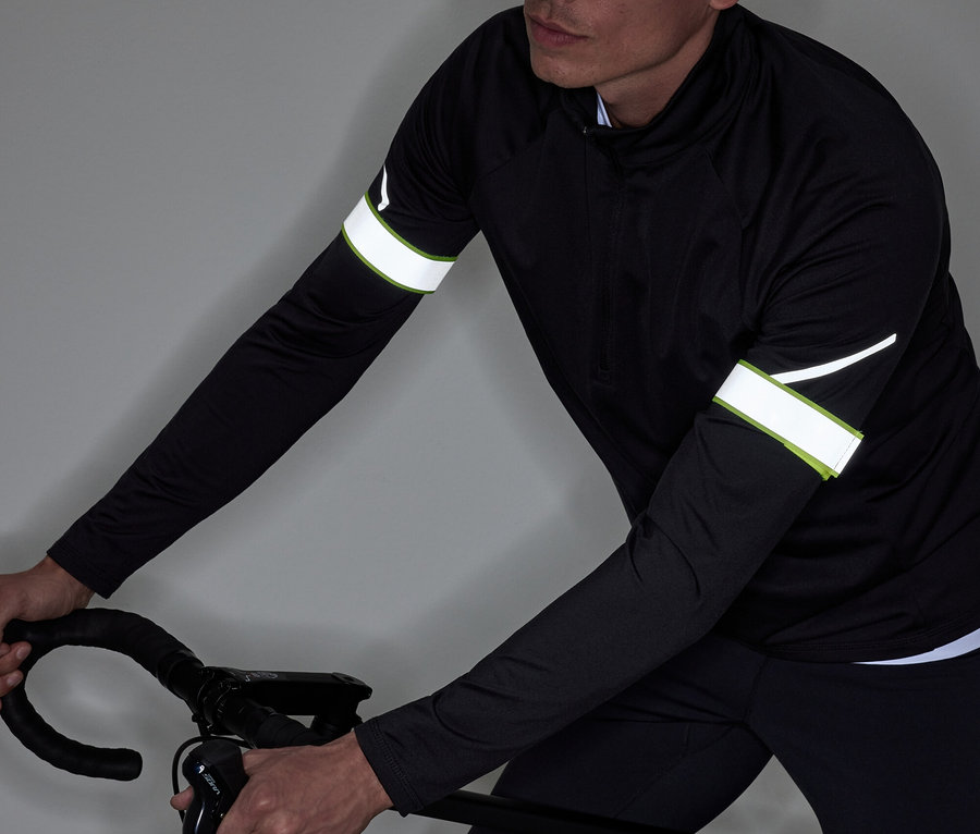 Un homme en tenue de sport noire fait du vélo.