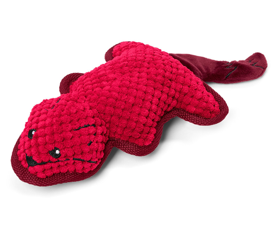 Un jouet en peluche rouge en forme d'animal allongé sur un fond blanc.