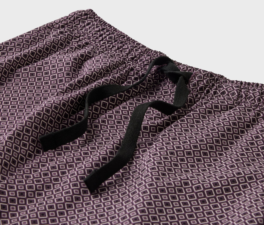 Gros plan d'un pyjama violet à motifs avec cordon de serrage noir.
