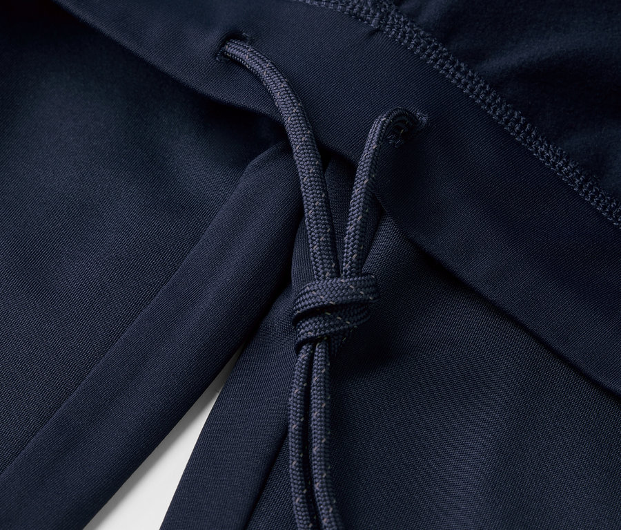 Gros plan sur un legging de sport coupe-vent bleu marine avec cordon de serrage.