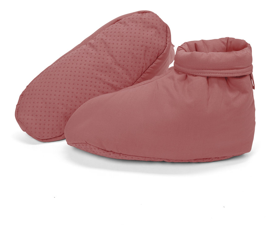 Deux chaussons roses avec semelle antidérapante sont posés l'un à côté de l'autre.