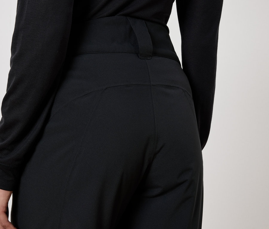 Vue arrière d'une femme portant un pantalon noir et un haut noir.