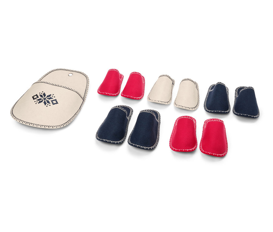 Étui à aiguilles à tricoter brodé à côté d'un ensemble de protège-pointes d'aiguilles à tricoter rouges, crème et bleues.