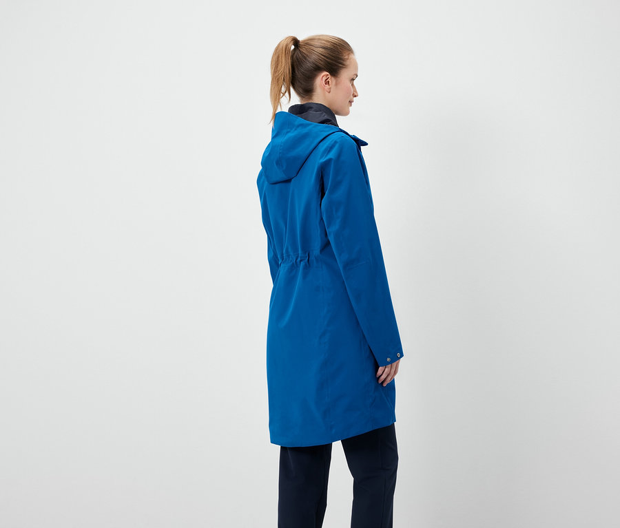 Une femme, dos à la caméra, porte un manteau bleu à capuche.