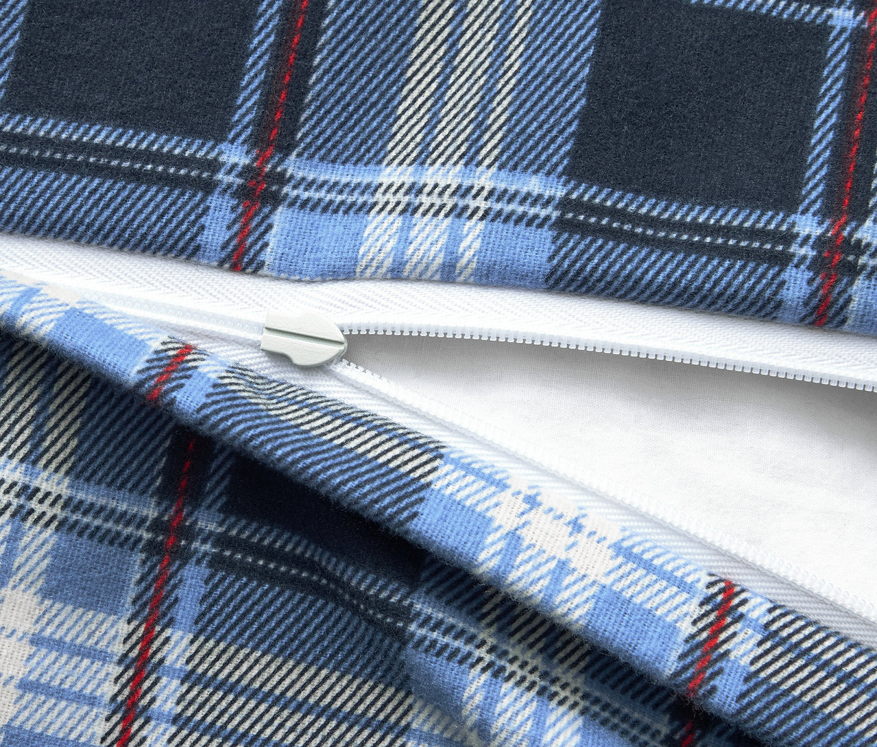 Gros plan d'un tissu à carreaux bleus avec une fermeture éclair blanche.