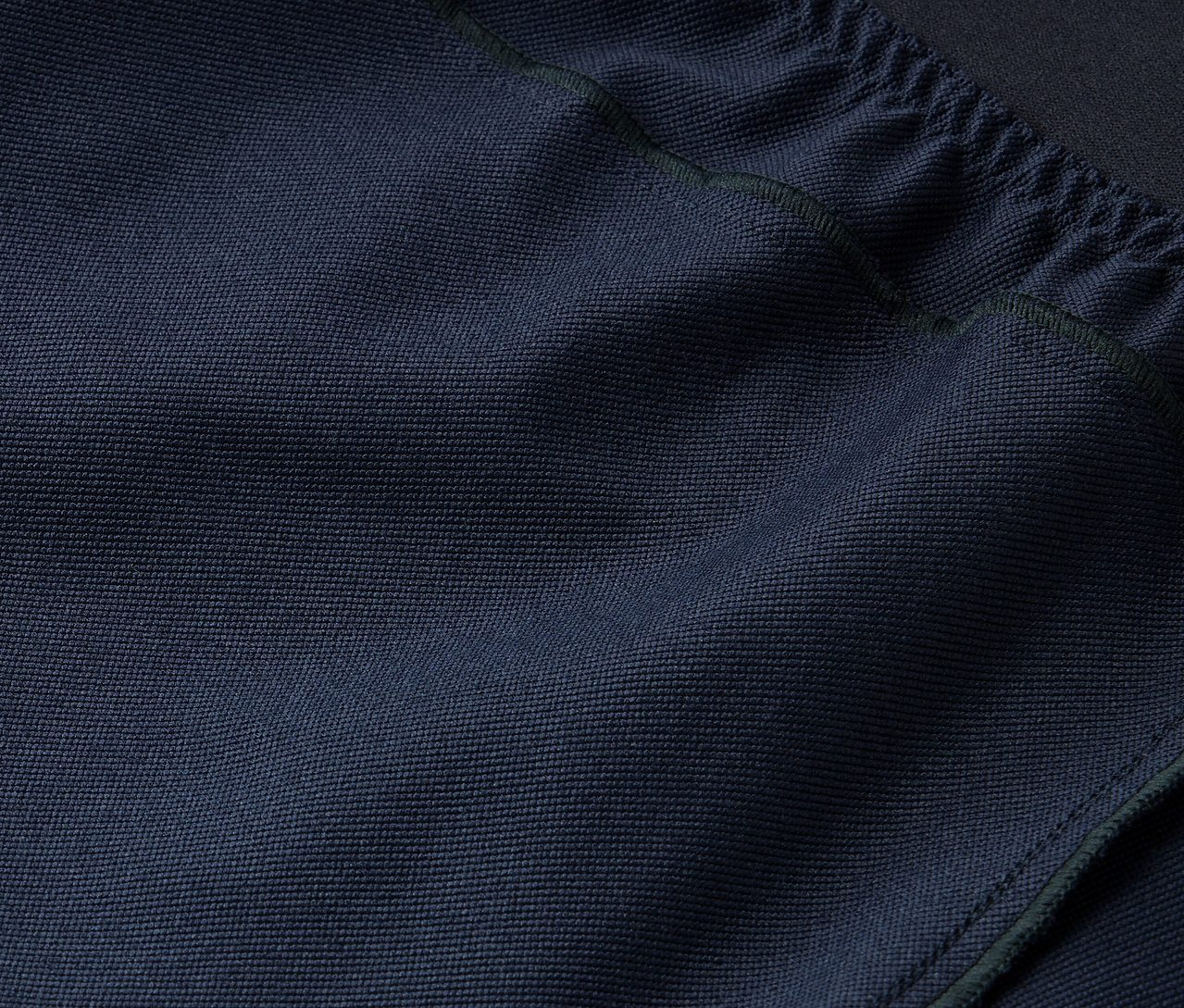 Gros plan sur la texture d'un tissu bleu marine avec cordon de serrage en haut.