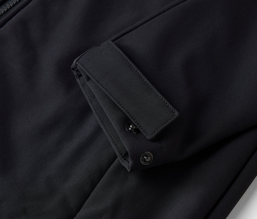 Gros plan sur la manche d'une veste noire avec poignet boutonné réglable.