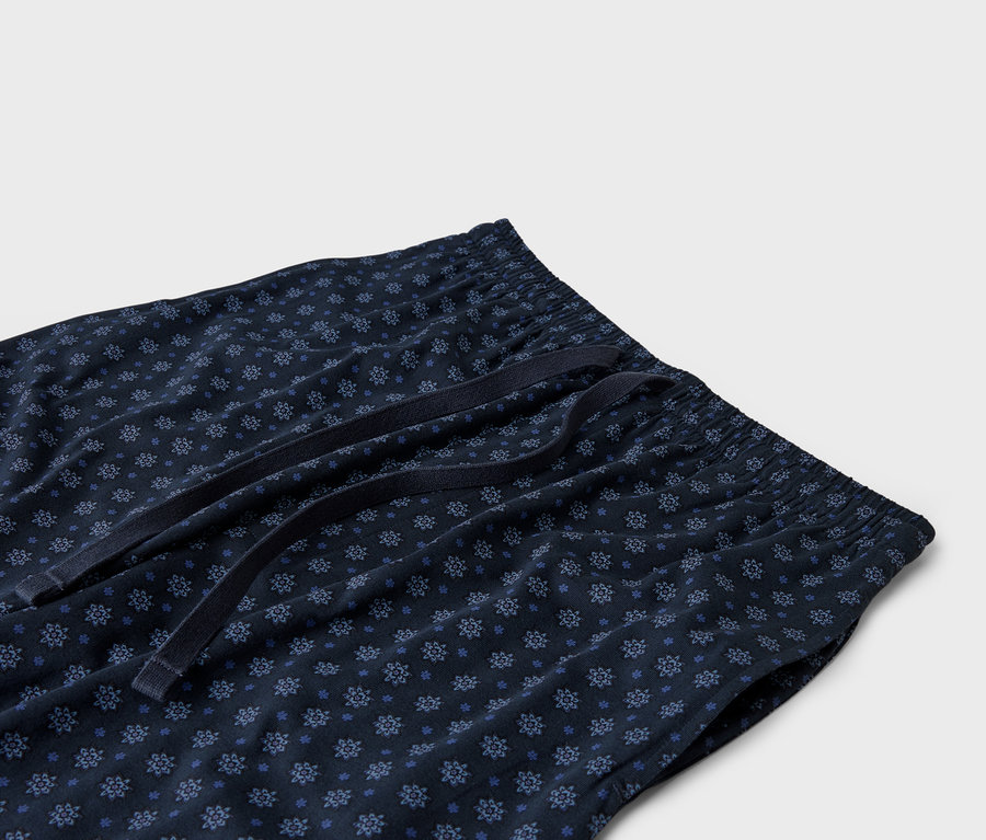 Gros plan d'un pantalon de pyjama bleu marine avec une taille élastique et un cordon de serrage.