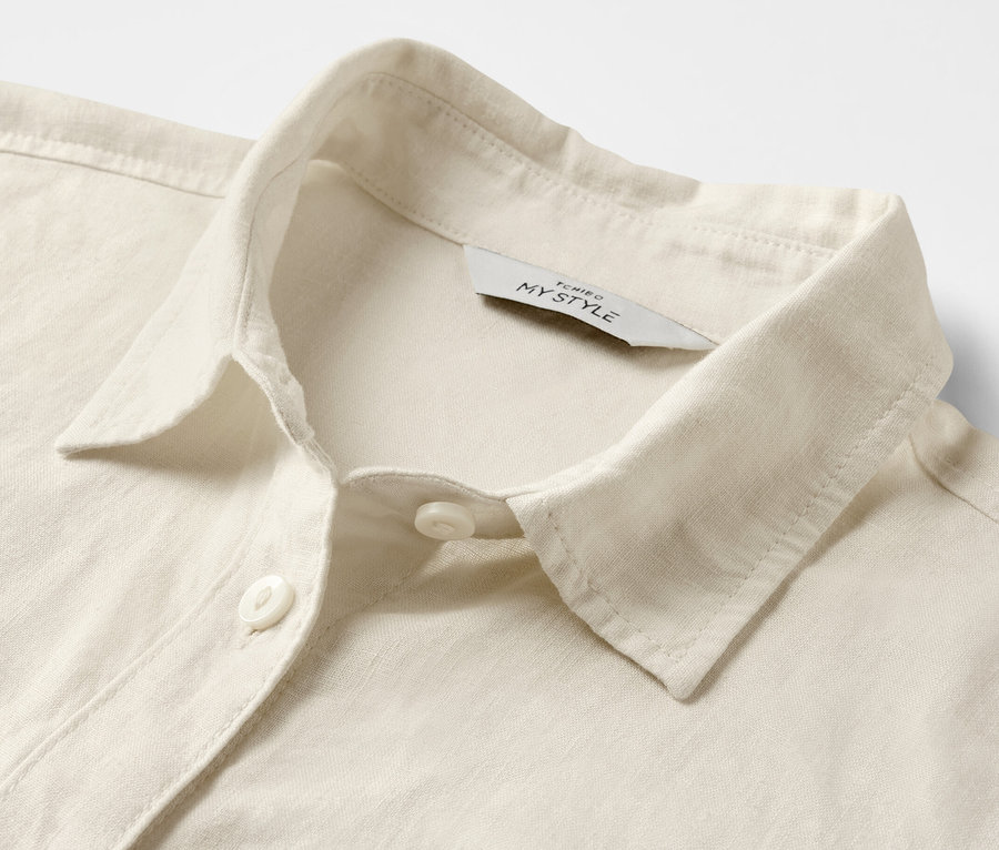Détail d'un chemisier en lin blanc crème.