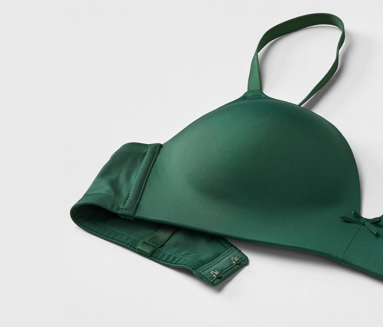 Gros plan d'un soutien-gorge vert avec bretelles réglables et fermeture à agrafes.
