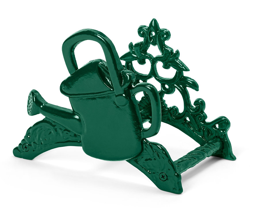 Un arrosoir miniature vert est posé sur un support orné.